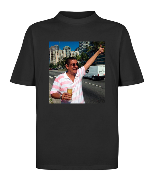 Camiseta oversized com estampa de Zeca Pagodinho brindando com cerveja e fazendo sinal de joinha, representando o espírito do samba carioca.
